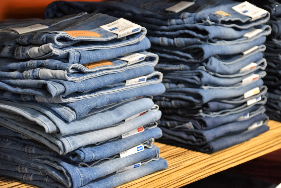 Pilha de calças jeans organizadas no estoque da loja